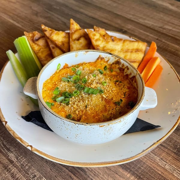 Buffalo chicken dip with scallions, served with crispy wonton chips, celery, and carrot sticks.