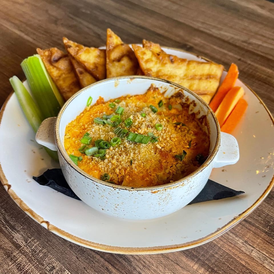 Buffalo chicken dip with scallions, served with crispy wonton chips, celery, and carrot sticks.